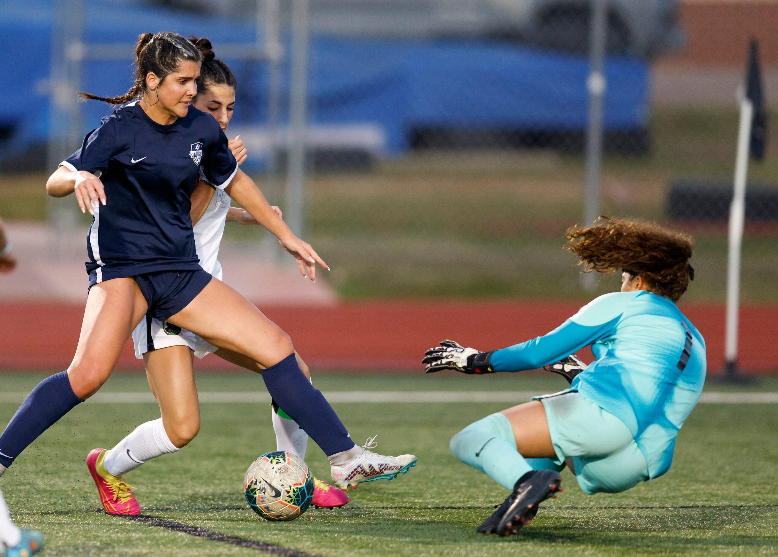 Flower Mound goalkeeper Maya Cordova (1) dives to make a save ahead of back Madison Vloitos...