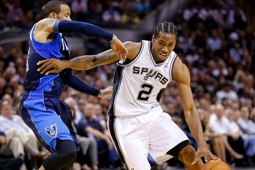 San Antonio Spurs forward Kawhi Leonard (2) battles around Dallas Mavericks guard Monta...