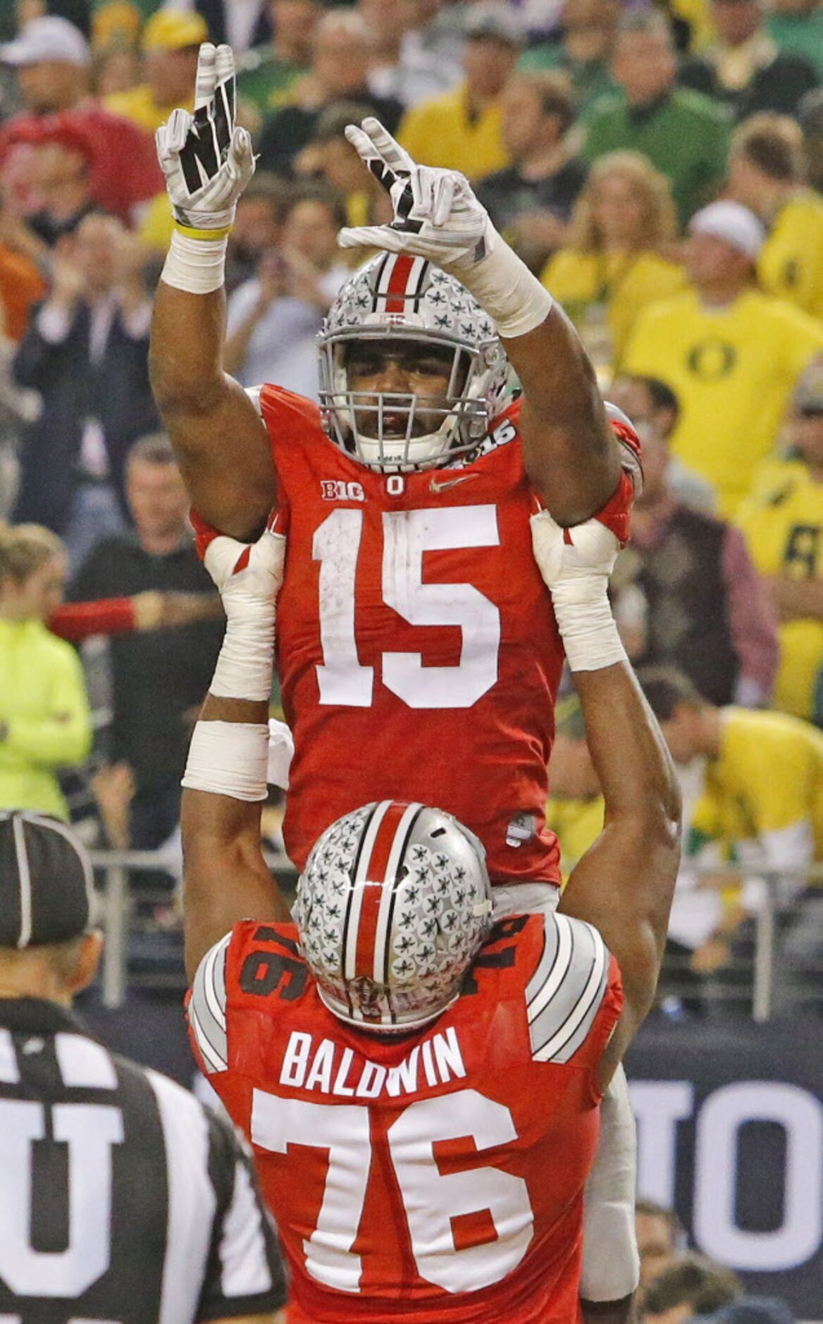 Ohio State Buckeyes running back Ezekiel Elliott (15) is hoisted by offensive lineman Darryl...