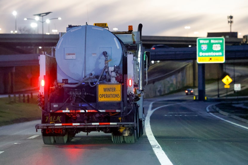 A TxDOT truck drives alongside East Rosedale Street as it prepares to spray brine ahead of...