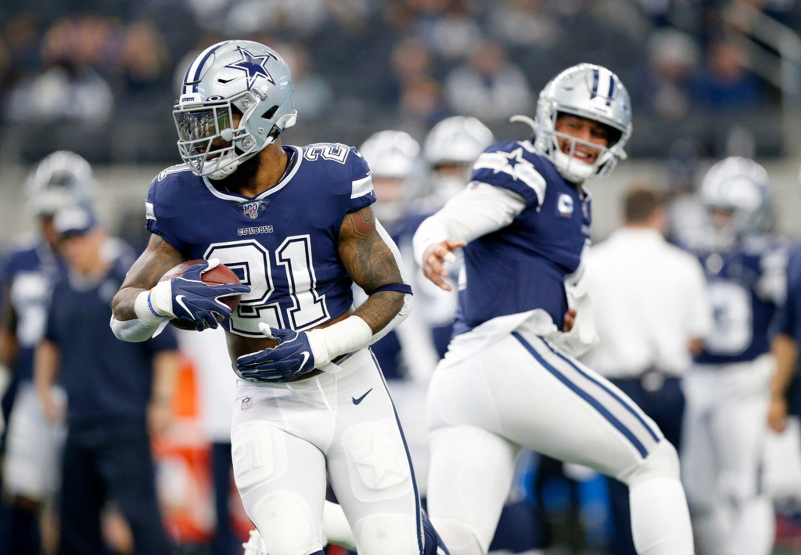 Dallas Cowboys quarterback Dak Prescott (4) hands the ball off to running back Ezekiel...