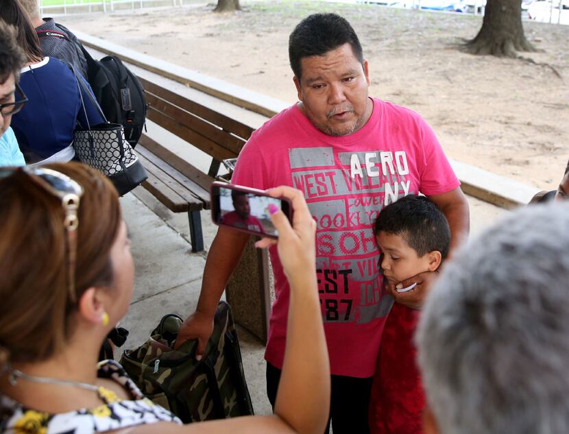 Jose Banda, an evacuee from Dickinson, Texas, speaks to the media with his son Justin Banda,...