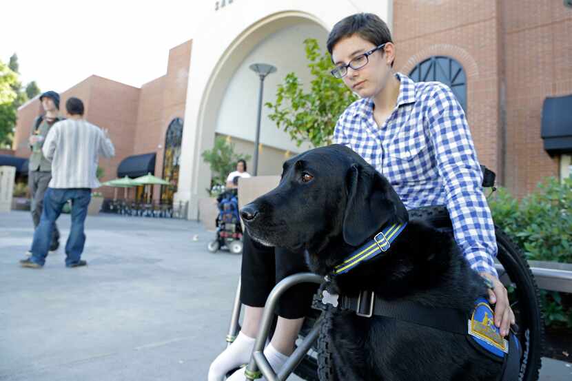 Wallis Brozman sits with her service dog, Caspin, outside a shopping mall in Santa Rosa,...