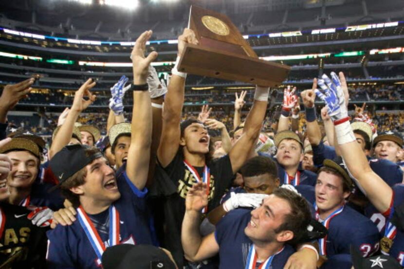 Allen linebacker Jakob Yandell holds the championship trophy high with his teammates after...
