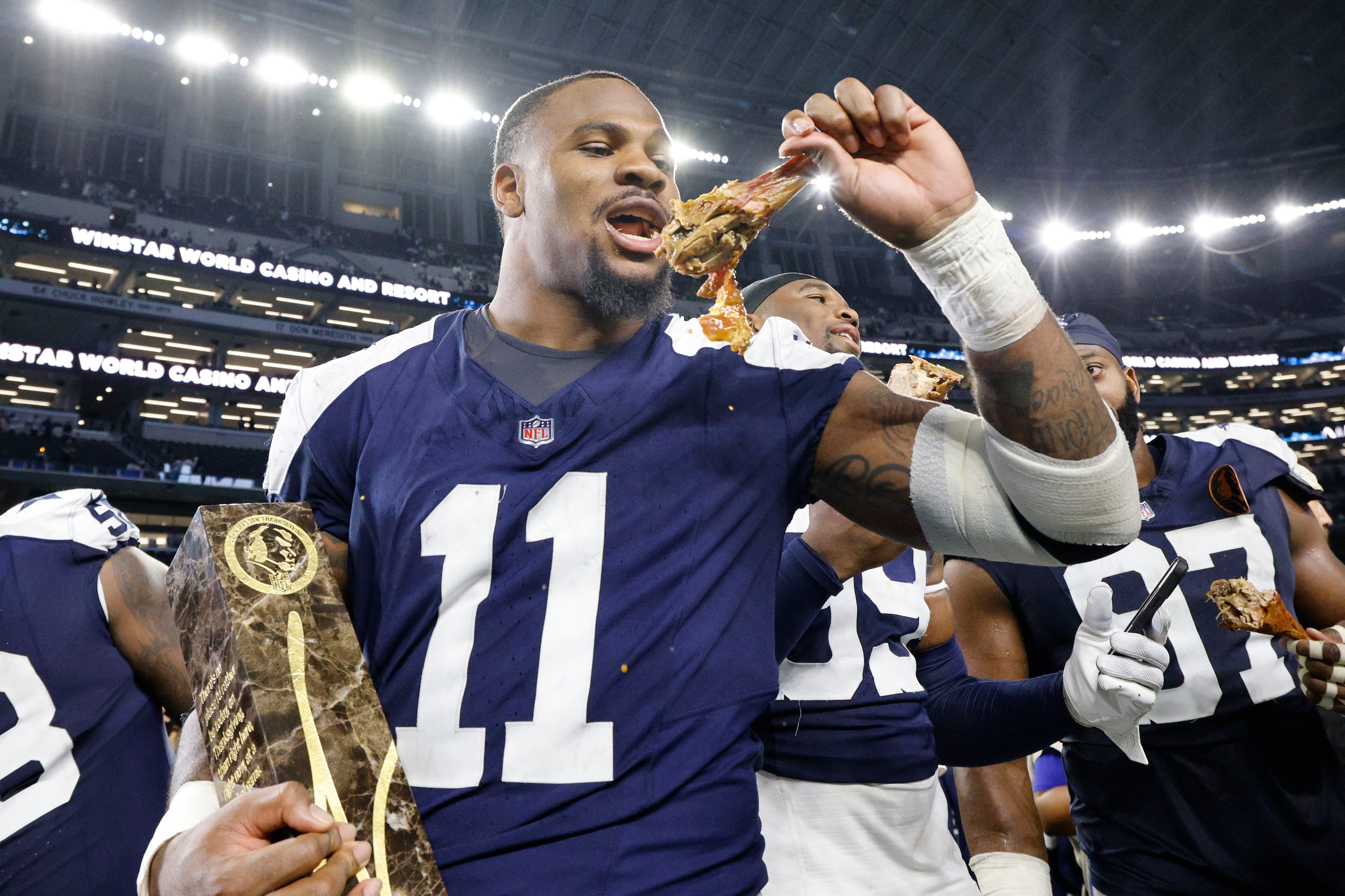 Dallas Cowboys linebacker Micah Parsons (11) eats a turkey leg after their 27-20 victory...