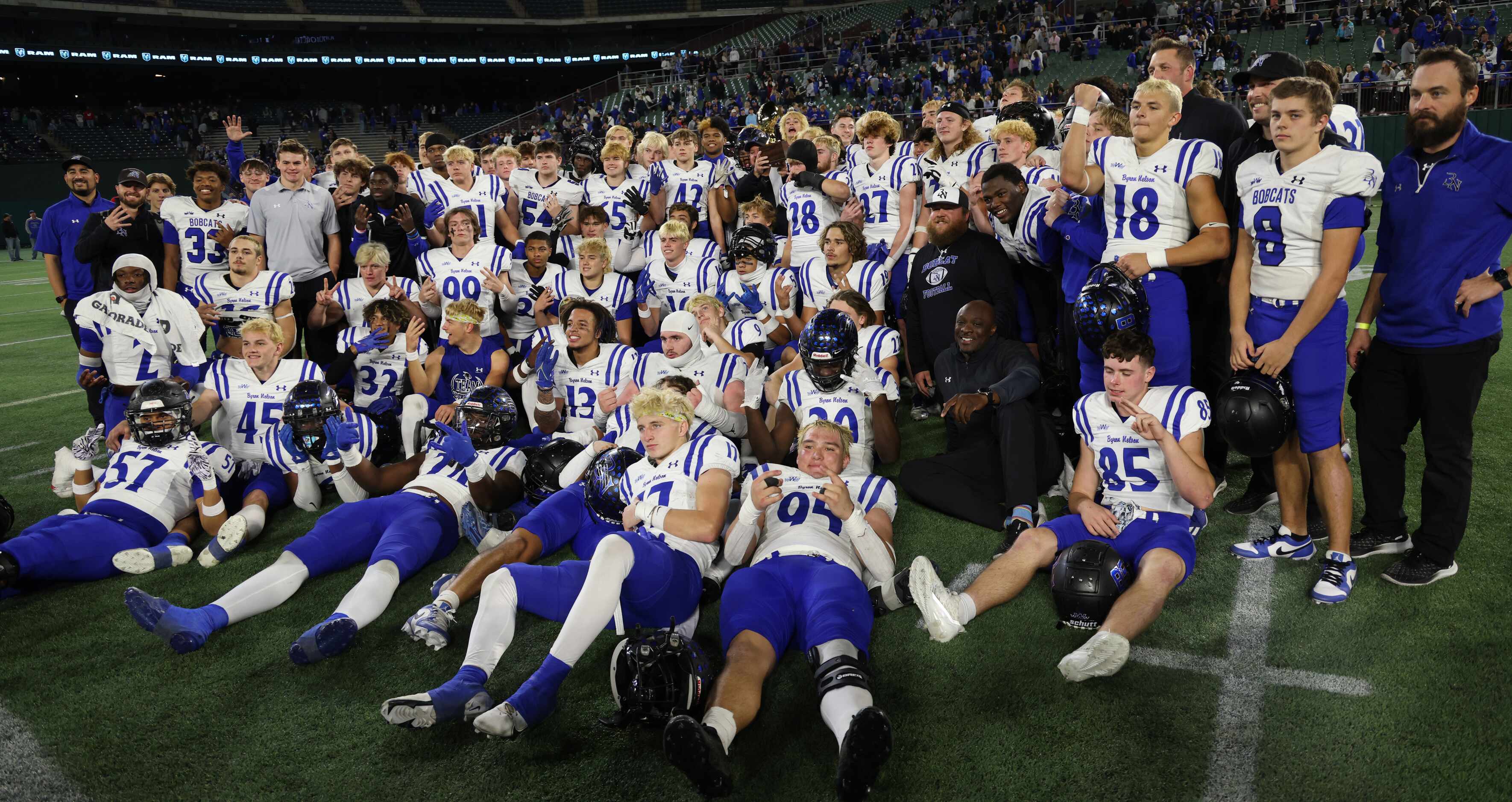 Byron Nelson players and coaches pose with the regional trophy after their 52-45 victory...
