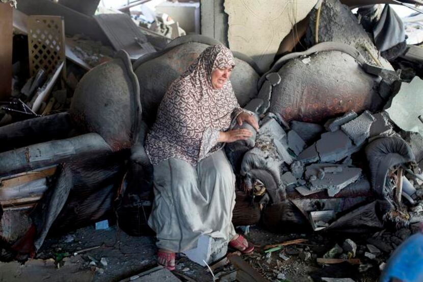 
A Palestinian woman sits distraught in the wreckage of an apartment building hit by an...