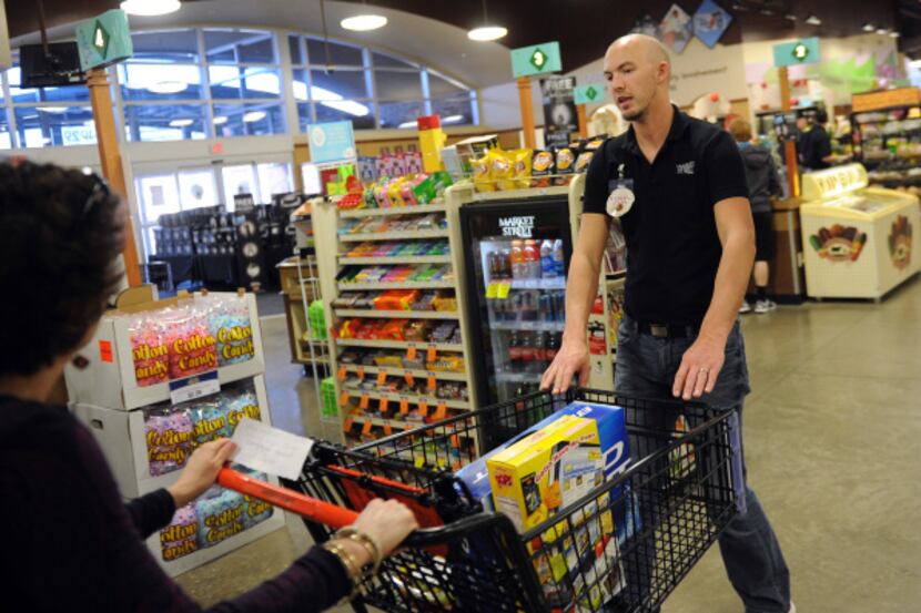 Alan Weems pulls the cart of a Market Street shopper to his register to speed up checkout.