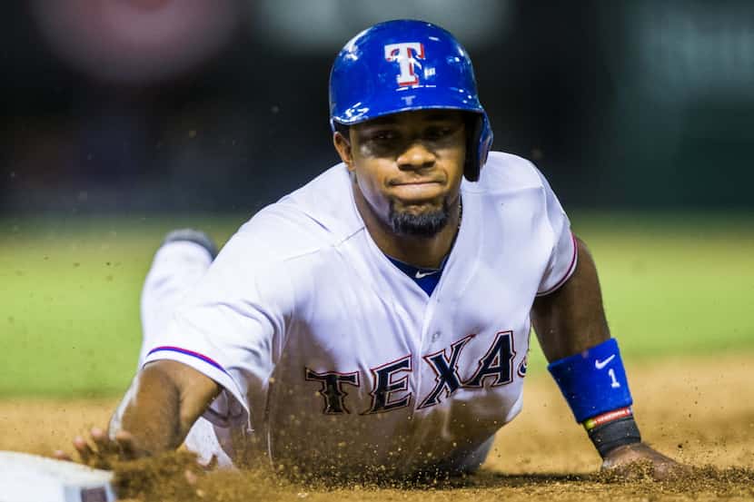 Texas Rangers shortstop Elvis Andrus (1) slides back to first base after trying to steal...