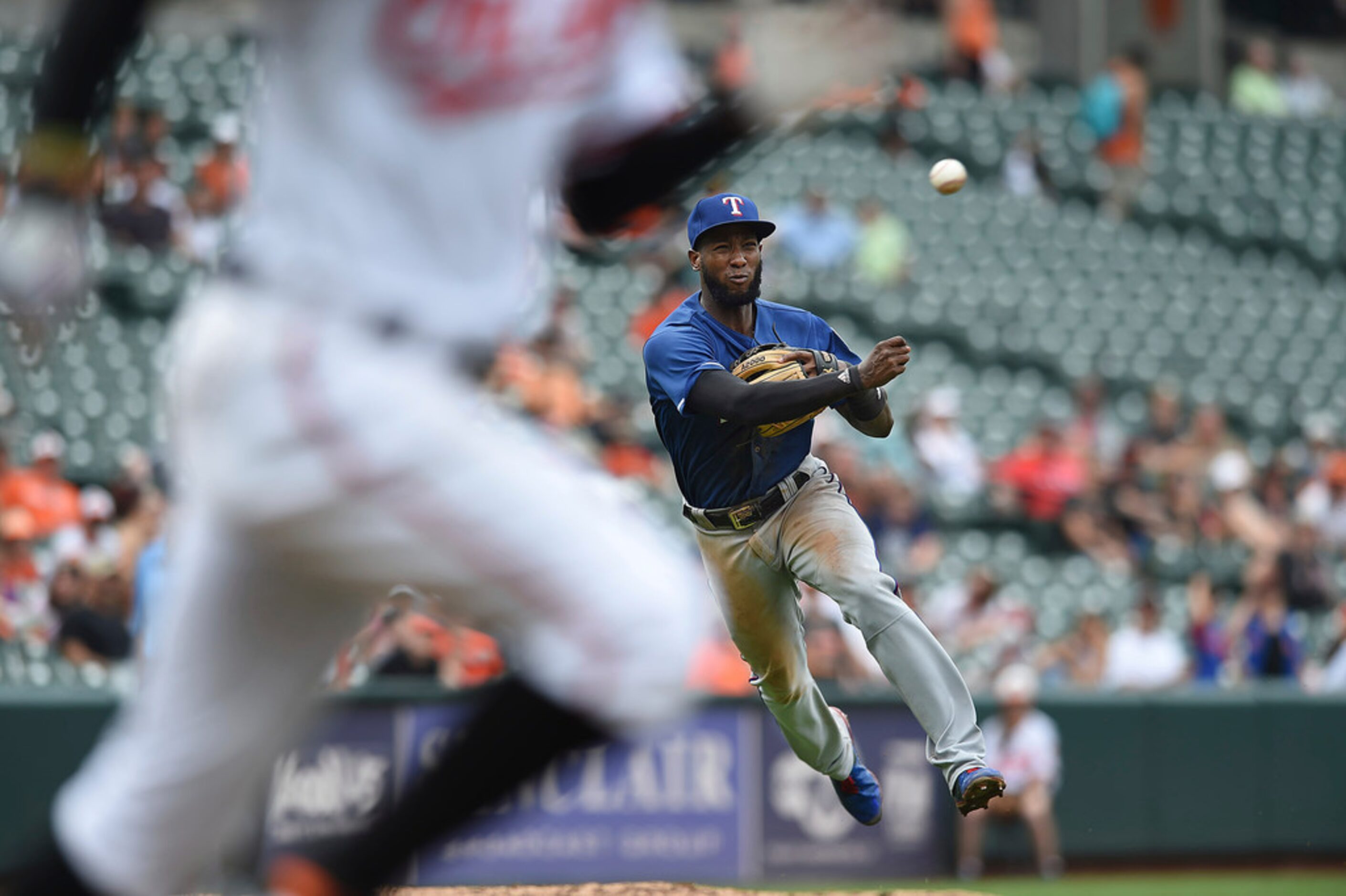 Baltimore Orioles' Adam Jones, left, races to first on a slow ground ball as Texas Rangers'...