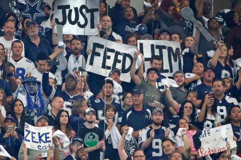 Dallas Cowboys fans hold signs for running back Ezekiel Elliott (21) during the Washington...