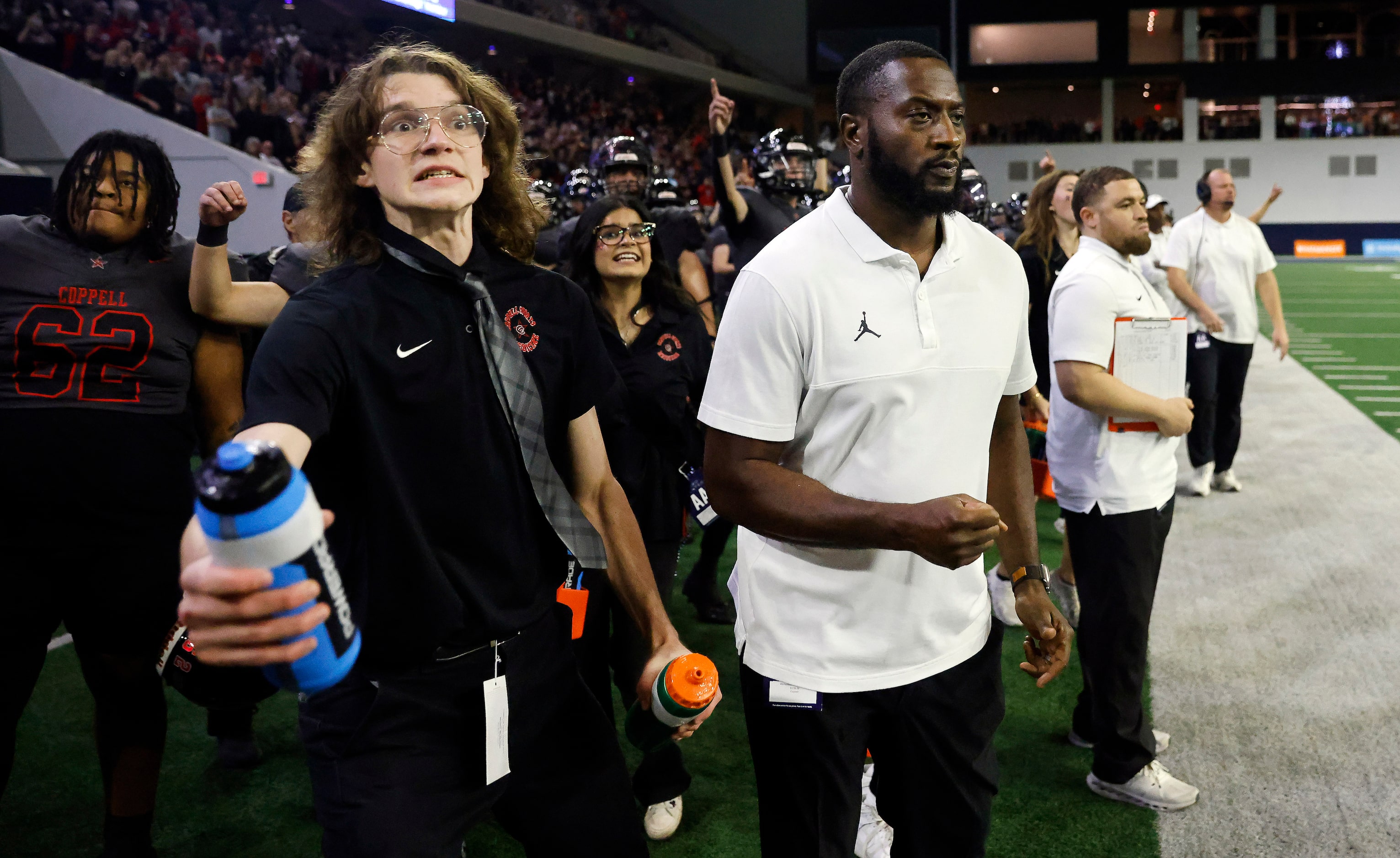 Coppell head coach Antonio Wiley (center, right) watches his running back O’Marion Mbakwe...