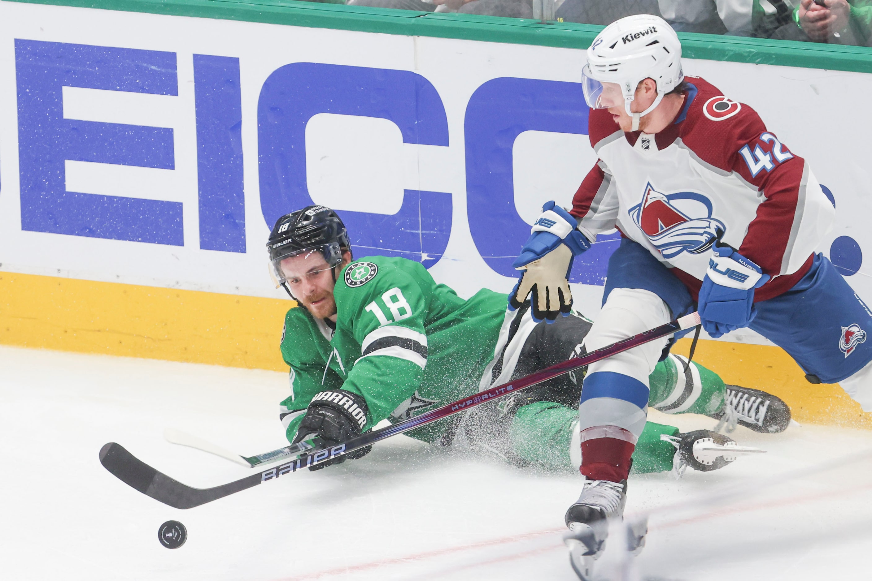 Dallas Stars center Sam Steel (18) reaches for a loose puck against Colorado Avalanche...