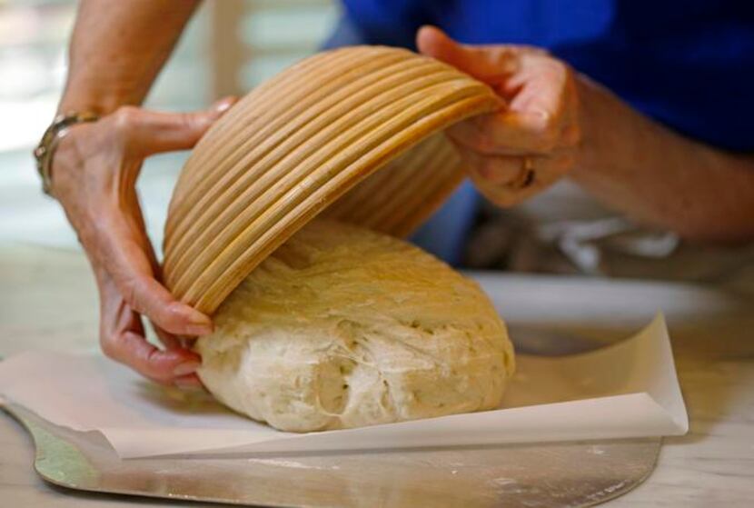 
After the dough rises, dump it out of the banneton onto parchment paper.


