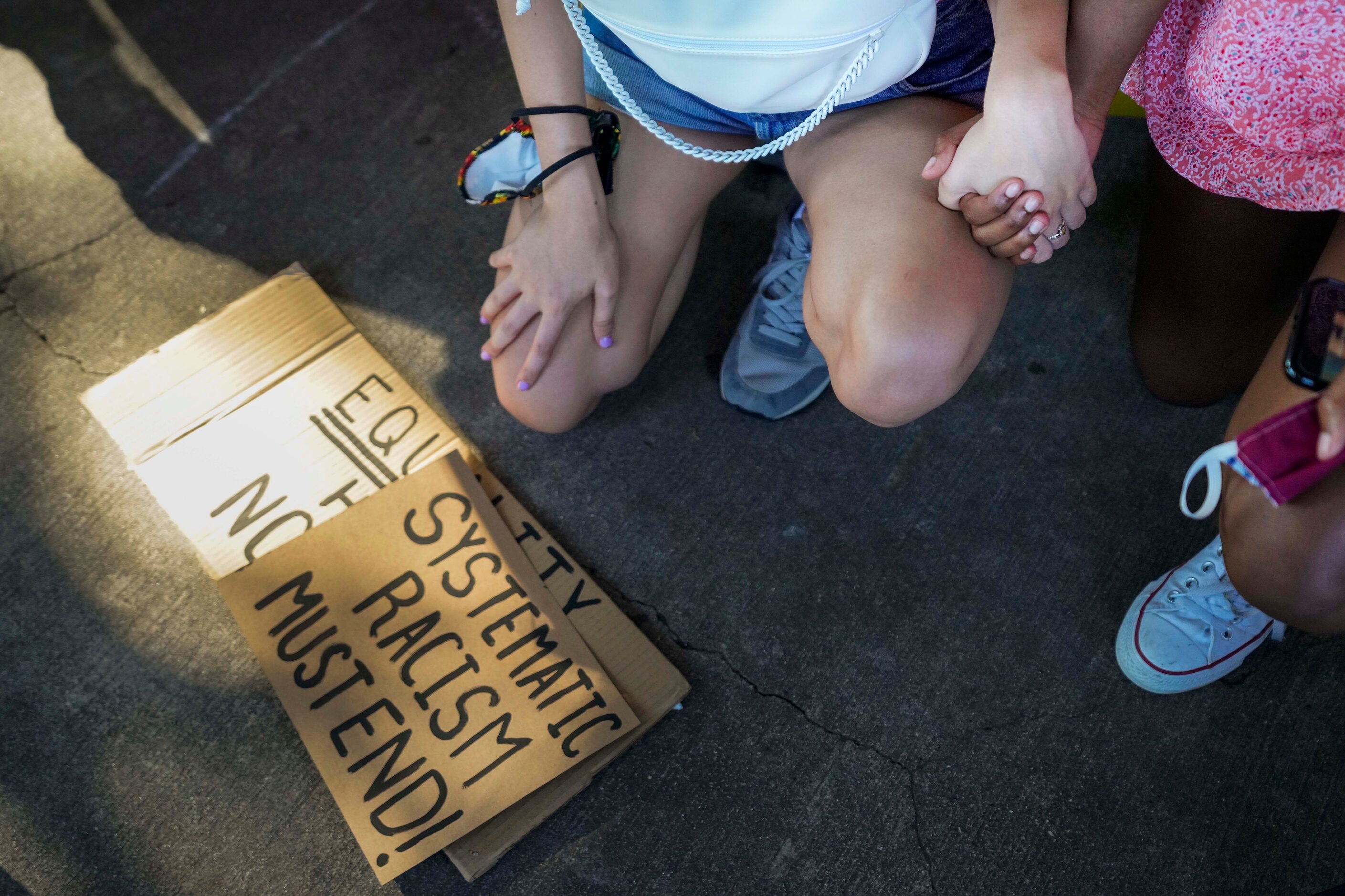 Organizers Bela Marcano (left) and Autumn Ray as they kneel for 8 minutes and 46 seconds...