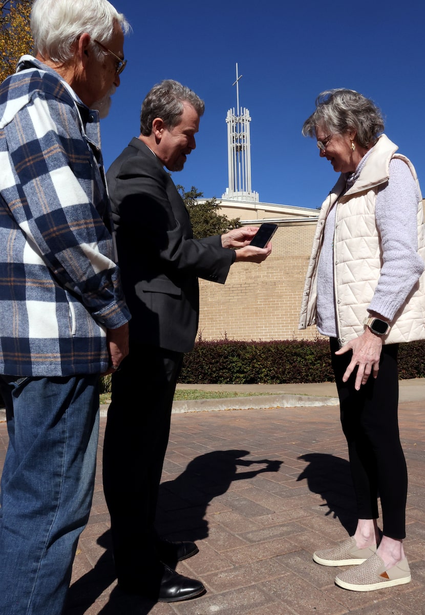 Father David Houk, center, shows Leah Stuekerjuergen how he activates the church bell with...