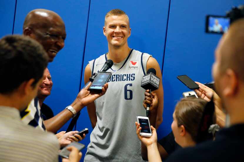Dallas Mavericks forward Kristaps Porzingis flashes a smile while be questioned by the media...