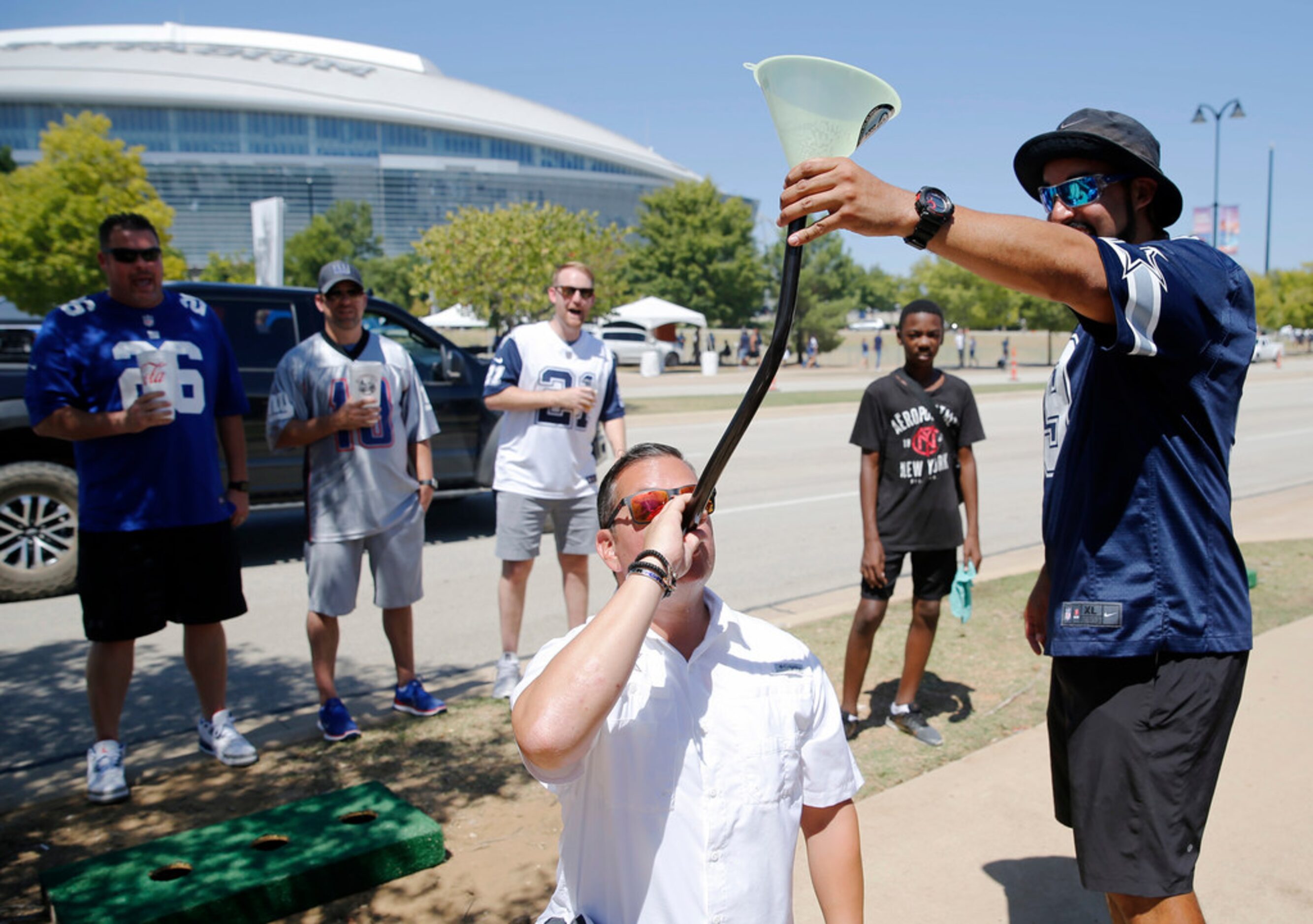 Juan Lopez of Wao holds the beer bong as Kevin Lopez of Waco drinks the beer before the home...