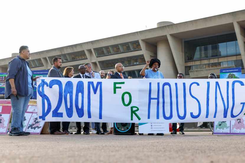 Dallas affordable housing advocates hold up a banner during a rally outside of Dallas City...