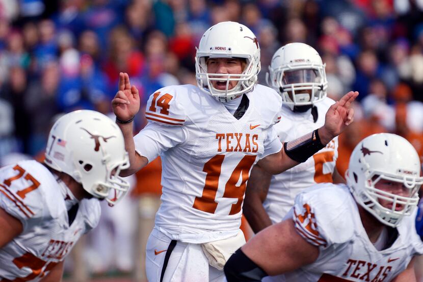 Texas quarterback David Ash (14) fights through an attempted tackle by Mississippi defensive...