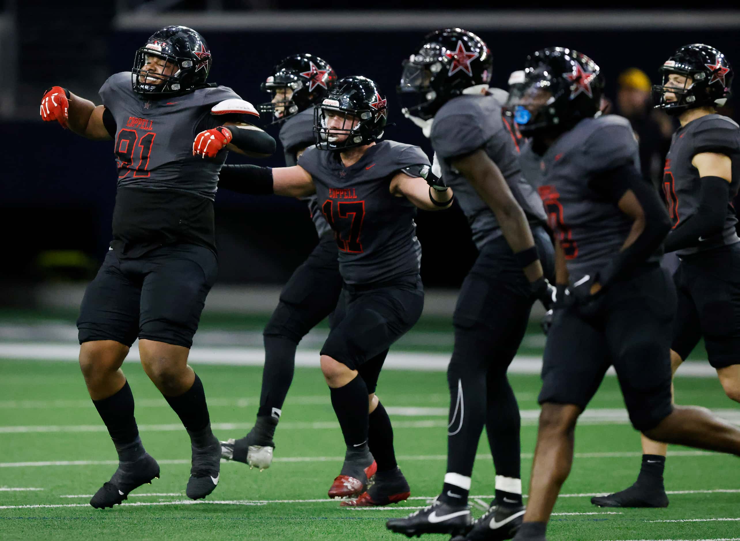 The Coppell defense celebrates their fourth down stop of Jesuit quarterback Charlie Peters...