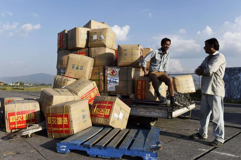 
Two airport workers wait with a load of aid coming from China at Kathmandu’s international...