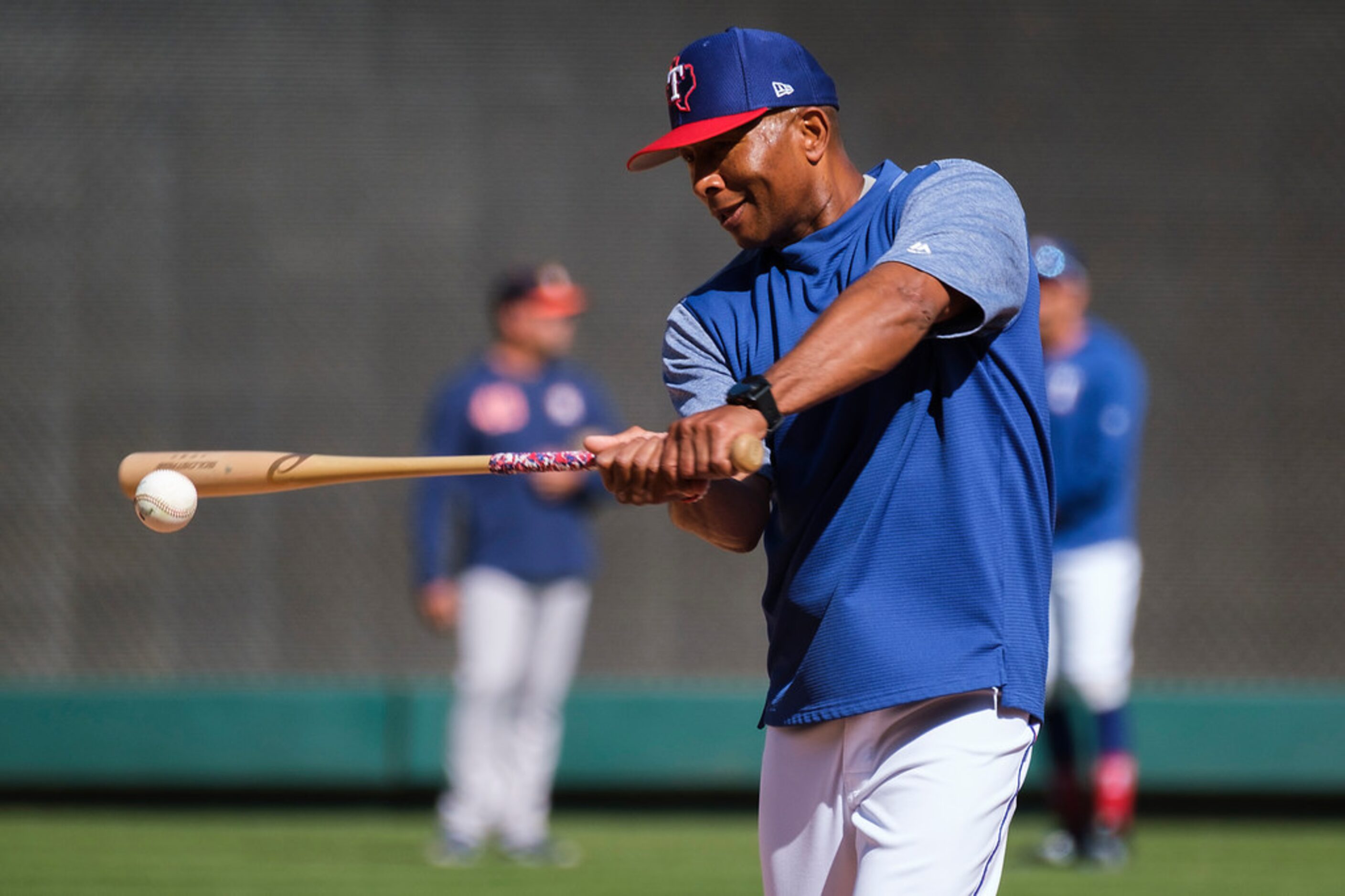 Texas Rangers third base coach Tony Beasley hits infield practice before a game against the...