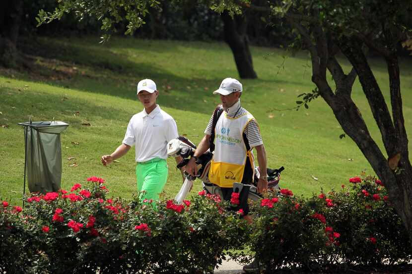 Chinese golfer Guan Tianlan walks with his American caddie, Bob Swanson, walk to the bridge...