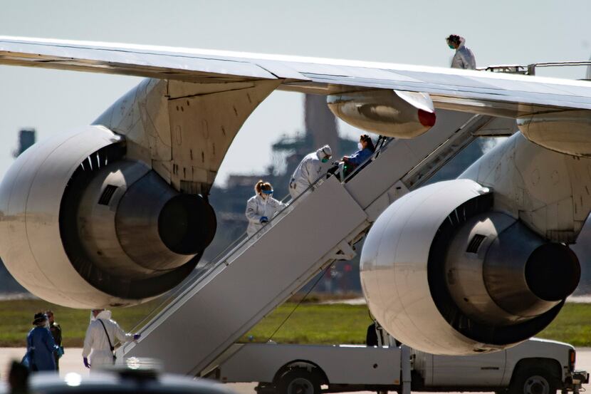 In this Friday, Feb. 7, 2020 photo, a passenger is helped off of a chartered 747 that...