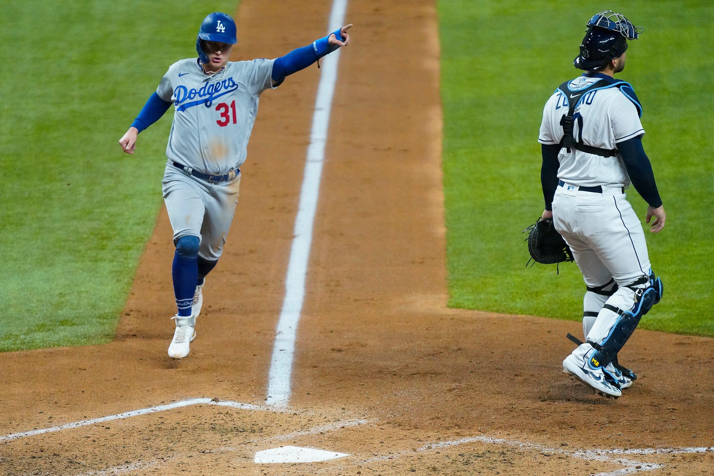 Los Angeles Dodgers left fielder Joc Pederson celebrates as he scores past Tampa Bay Rays...