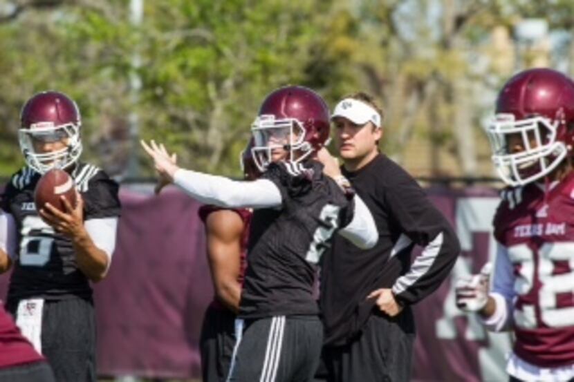 New Texas A&M assistant coach Jake Spavital watches quarterback Johnny Manziel in spring...