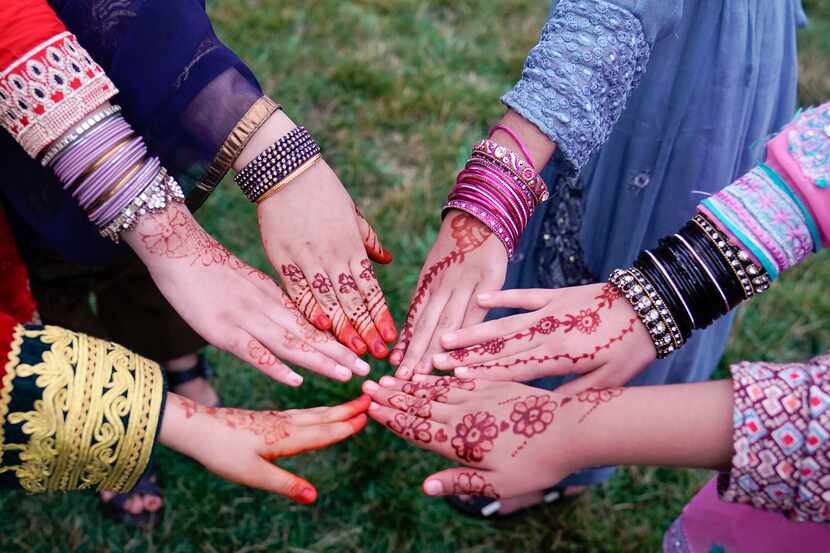 Afghan refugee girls pose with their Henna-designed hands to celebrate Eid al-Adha. It takes...