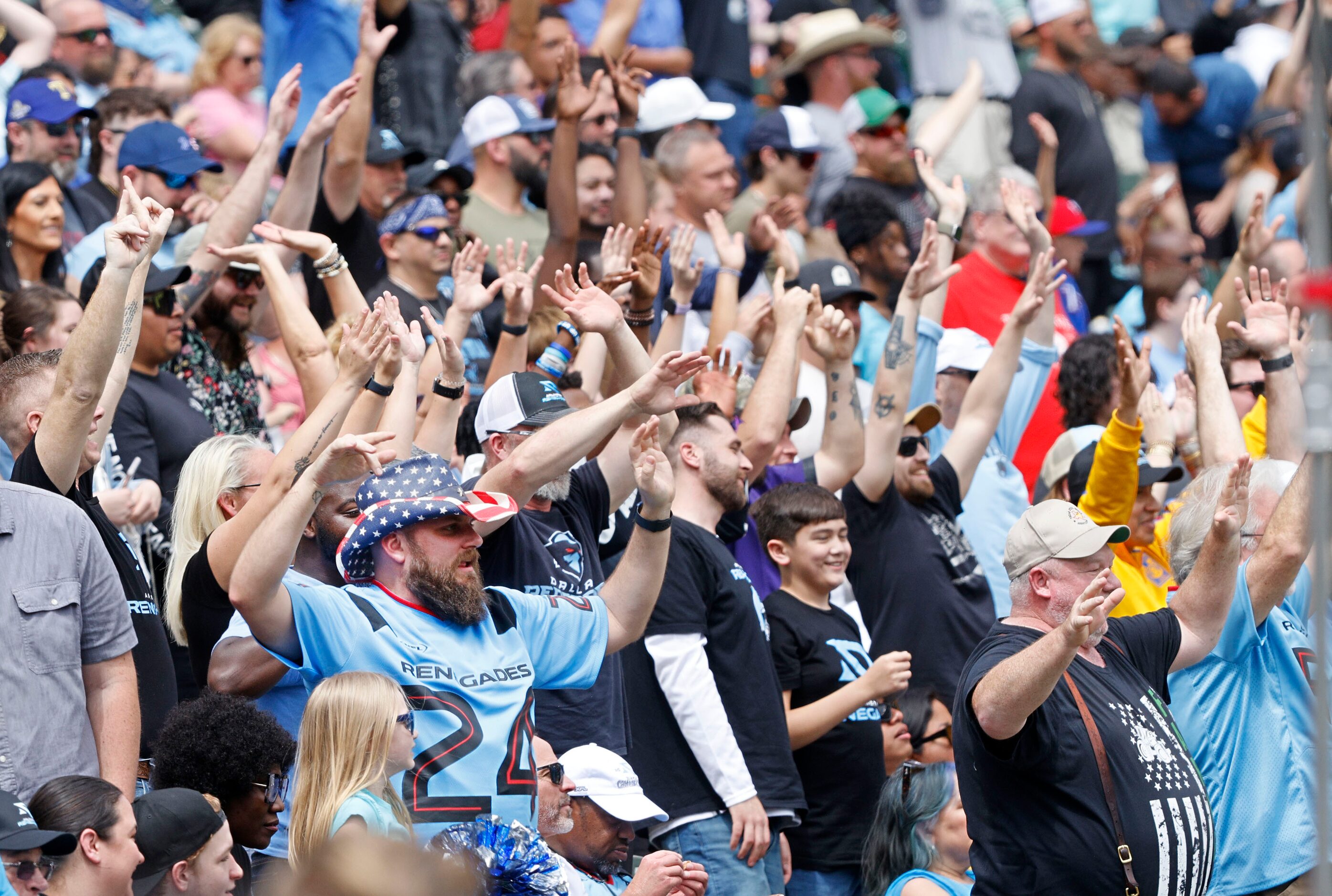 Fans try to get T-shirts during a time out in the first half of a football game between...