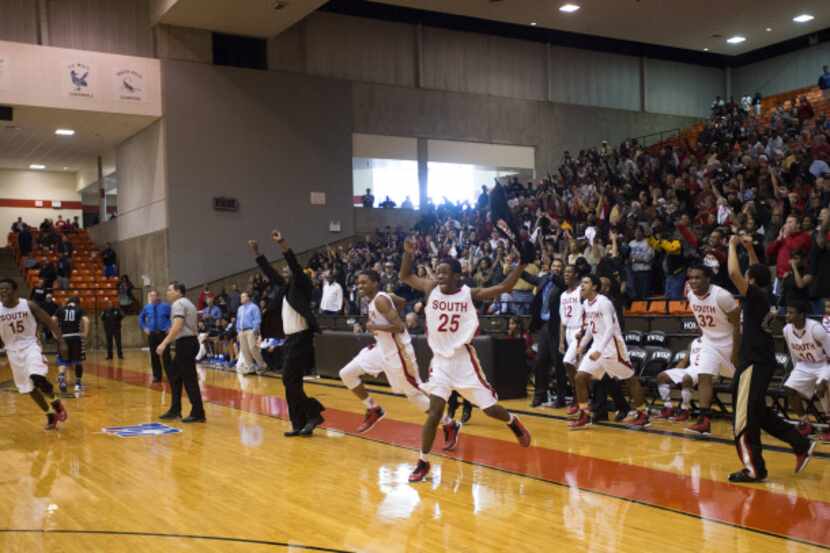 South Grand Prairie players and coaches leap off the bench as the final buzzer sounds in...