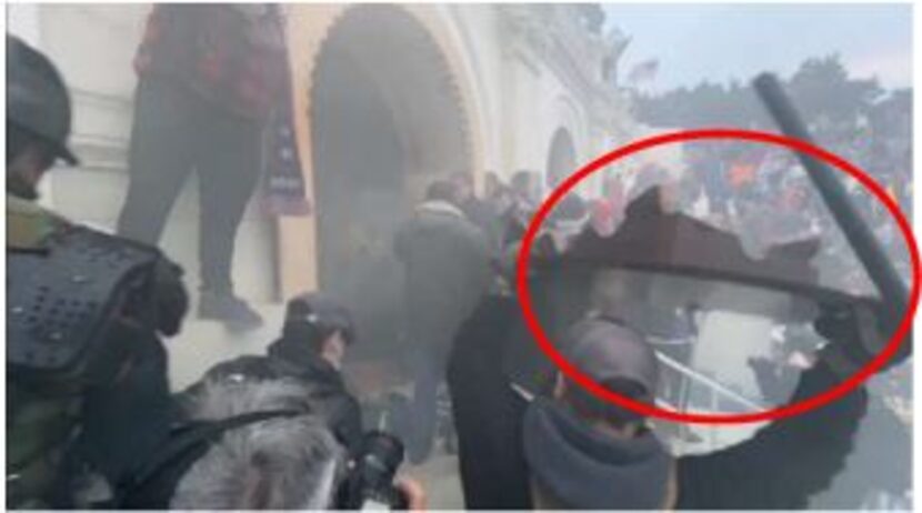 The FBI says this image from a video shows Ballard throwing a tabletop (circled in red) at...