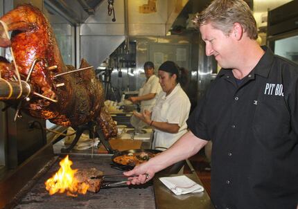 In this 2012 file photo, Tim Love grills a 60-ounce Tuscan porterhouse steak at Woodshed...