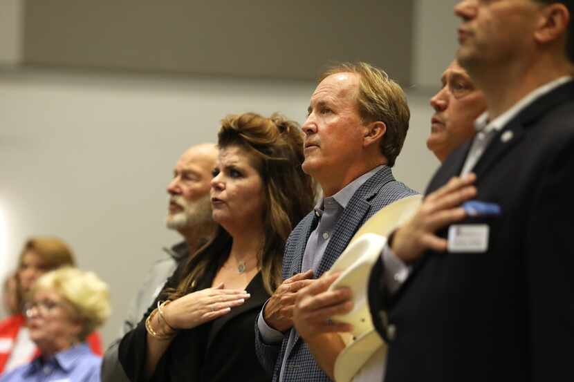 Ken Paxton, center, says the pledge of allegience during the GOP County Executive Meeting at...