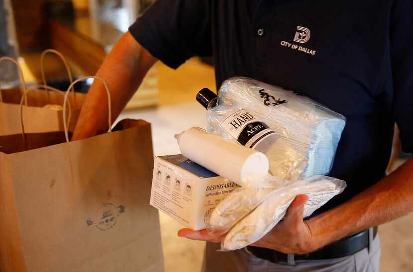 Dallas City Council member Chad West pulls out some of the PPE items he handed out to Del...