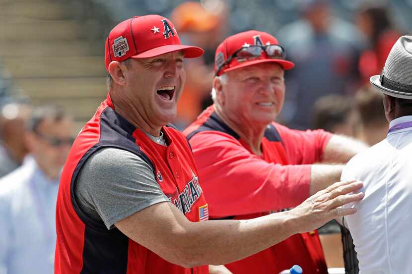 American League manager Jim Thome laughs as players take batting practice for the MLB...