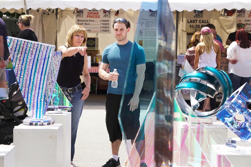 Christine Riggs and Brandon Allen browse through the works of visual artists at the 2018 Art...