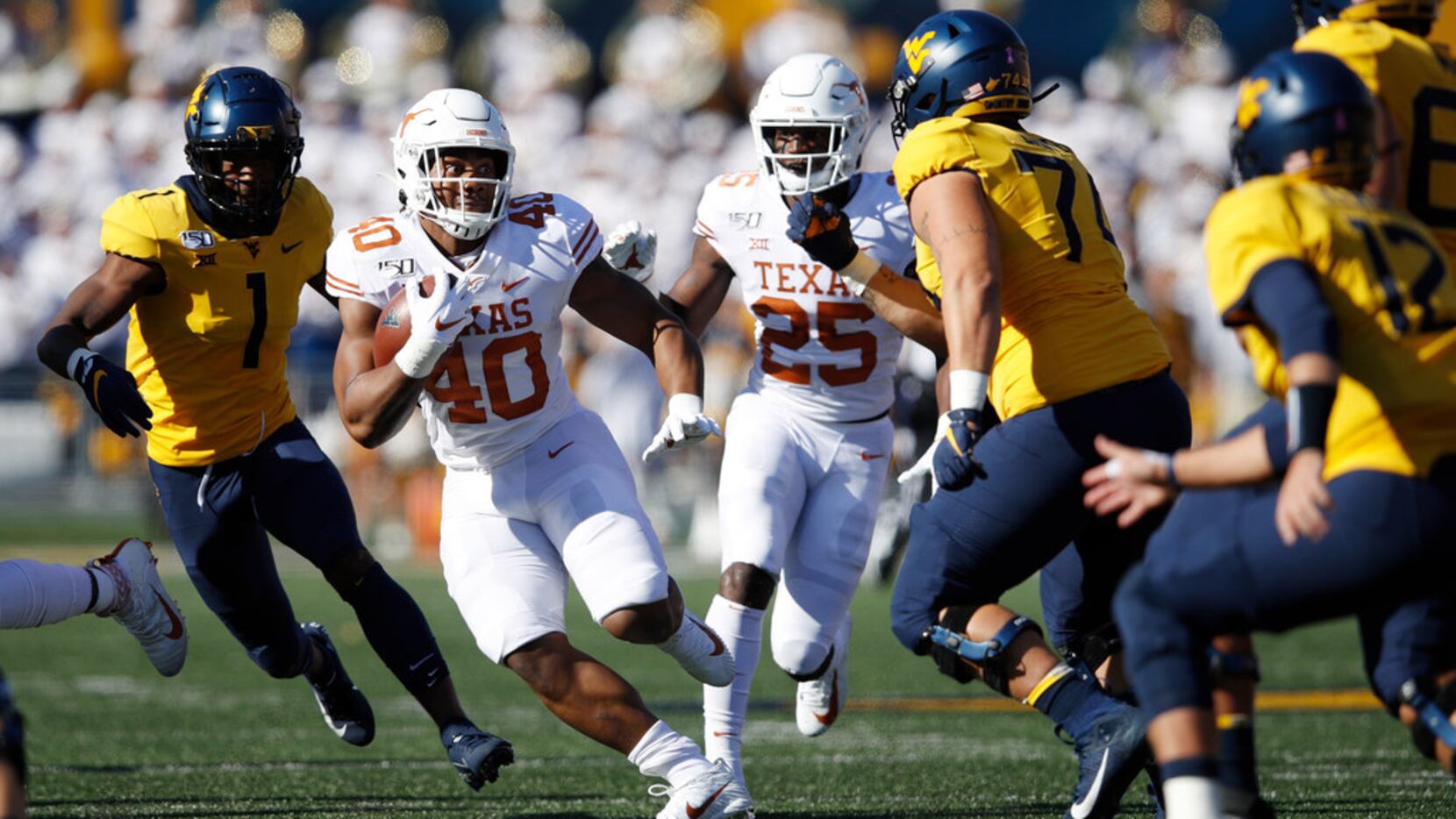 Ayodele Adeoye #40 of the Texas Longhorns runs with the ball after intercepting a pass in...