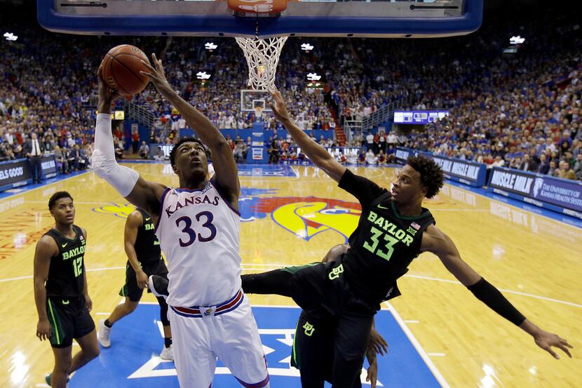 Kansas' David McCormack (33) gets past Baylor's Freddie Gillespie (33) to dunk the ball...