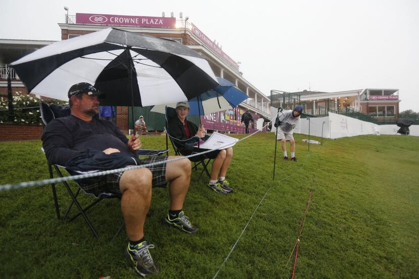 Glen Weeks and his son Corey Weeks, 17, left, from Denton, snag a spot on the 18th green as...