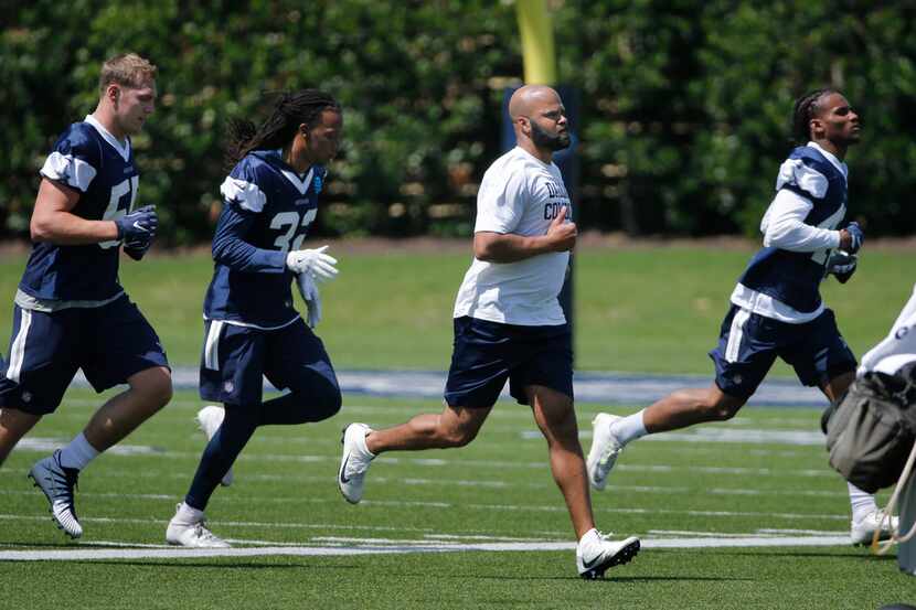 Kris Richard (center), new secondary coach runs with players during the Dallas Cowboys...