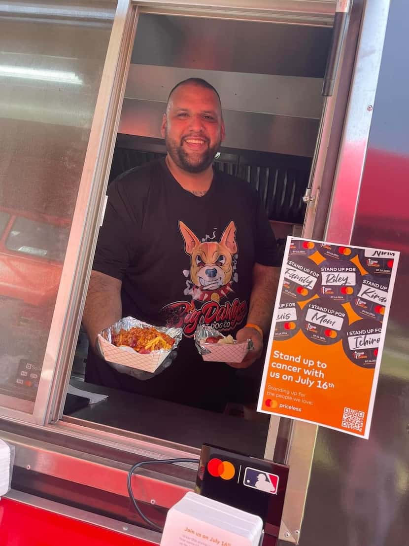 Big Dawg Hot Dogs co-owner Juan Acosta stands at the window of his food truck during...