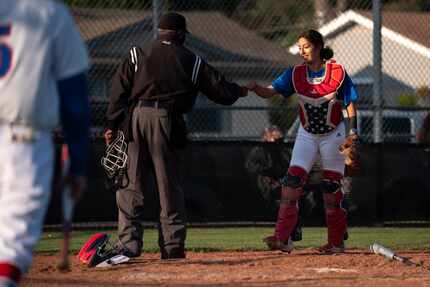 Adamson High School senior Tatyana Beltran (2), receives a fist bump from an umpire after a...
