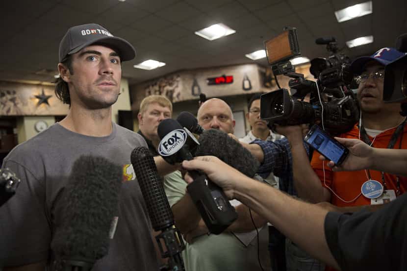 Texas Rangers pitcher Cole Hamels (left) talks to the media as he and teammates clean out...