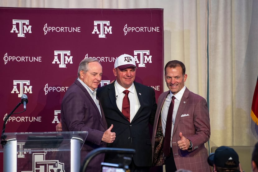 Texas A&M president Mark Welsh III, left, new head coach Mike Elko, center, and athletic...