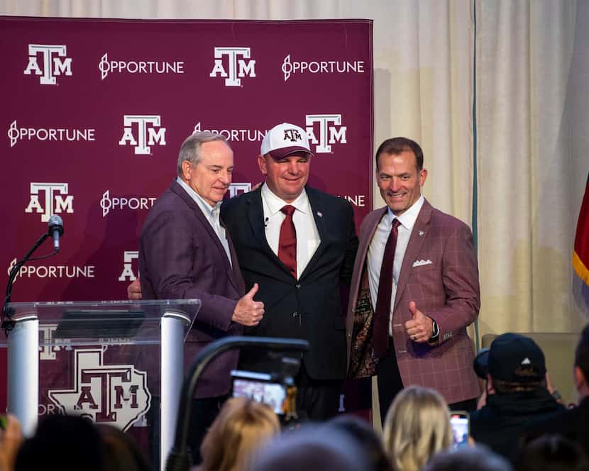 Texas A&M president Mark Welsh III, left, new head coach Mike Elko, center, and athletic...
