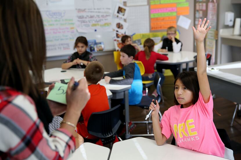 Olivia Wilson (right) raises her hand while teacher Grace Hanchey asks a question while the...